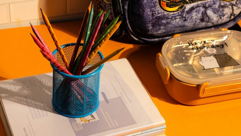 Blue school backpack on a table with stationery