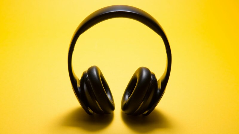 Black over-ear wireless headphones on a desk