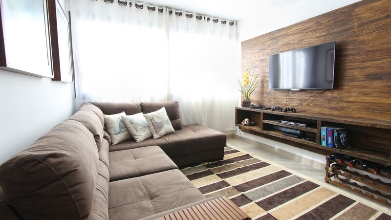 Wall-mounted flat screen TV above a sofa