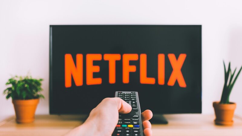 Hand pointing a remote control at a television